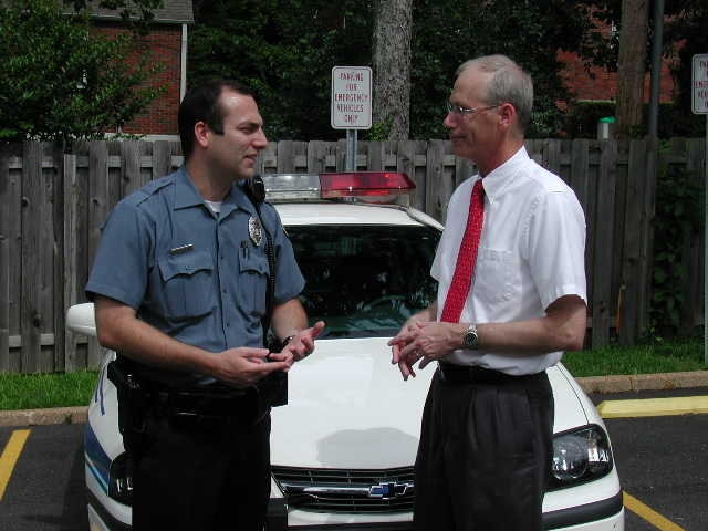 Photo courtesy of Rick Stream. Stream discusses crime issues with a local police officer.
