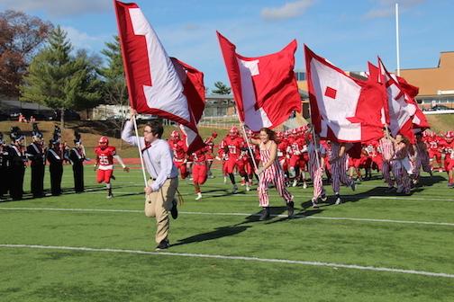 Pep Nation and the  football team run onto the field before the game to get the crowd pumped up. 