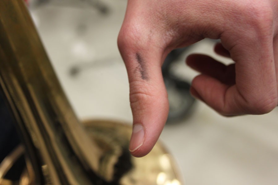 A black smudge on the thumb of a Trombone player