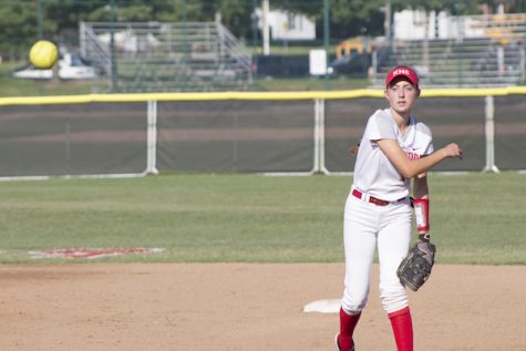 Lauren Hammett, junior, throws a ball to her teammate at first base.