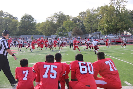 Freshman boys watch on the sideline as Cameron Macon, freshman, runs the ball up the field.