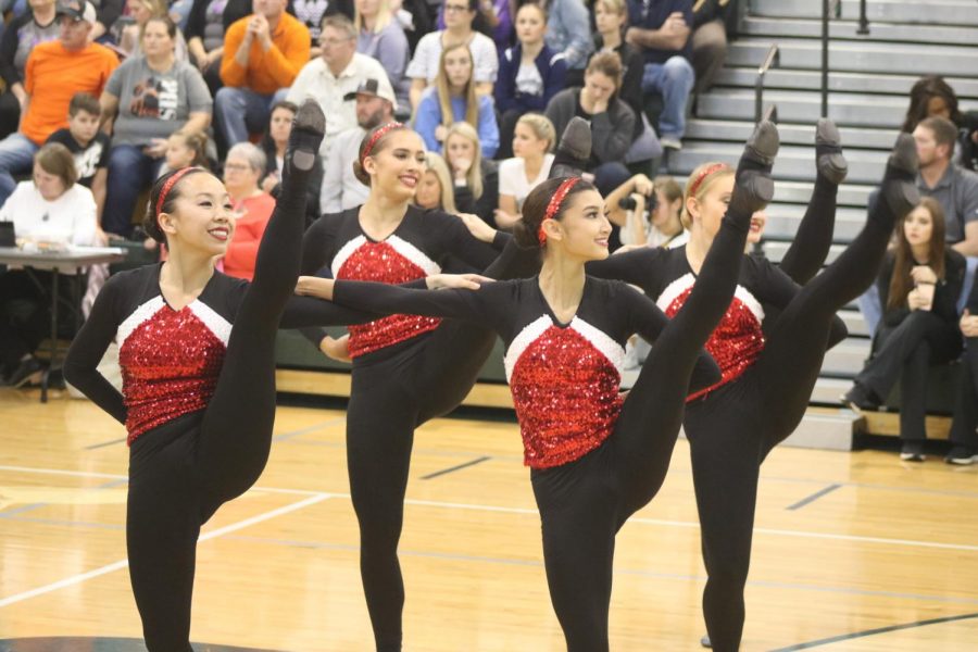 Megan Cleveland, junior, and Naomi Thomson, junior, stand arm-in-arm as they perform kicks.