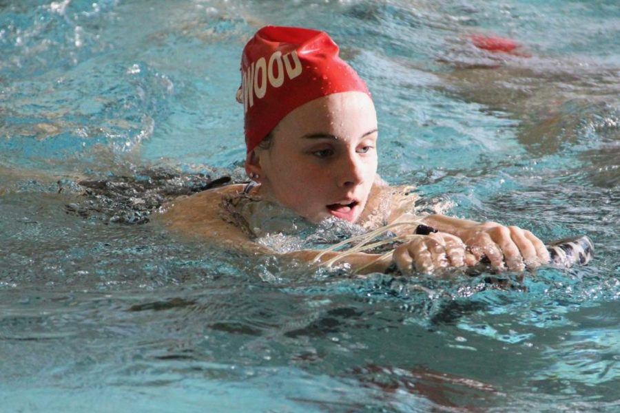 Annie+George%2C+freshman%2C+glides+through+the+water+using+a+kick+board+during+warm-ups.