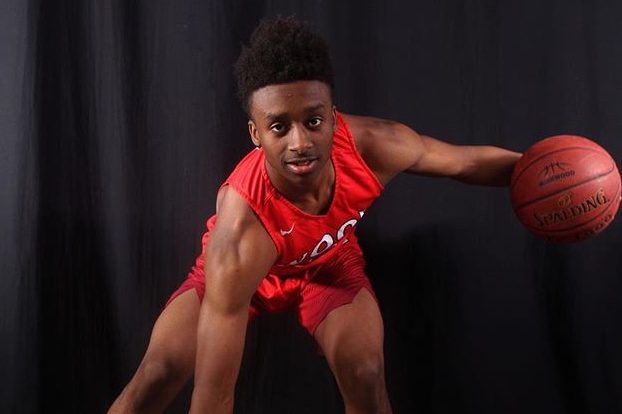 Damien Loyd doing a crossover pose with a basketball. 