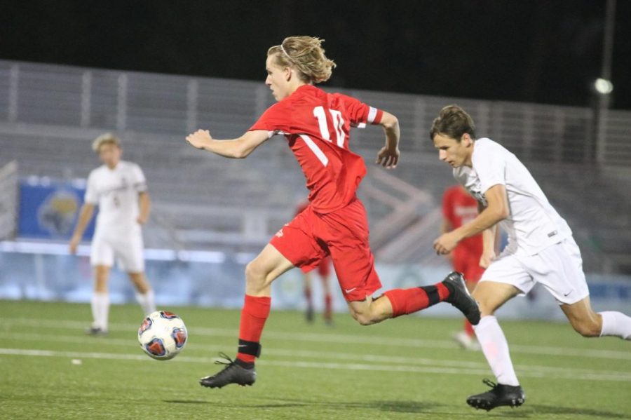 Sawyer Hardy, senior, strides through the air as he dribbles the ball towards the net.