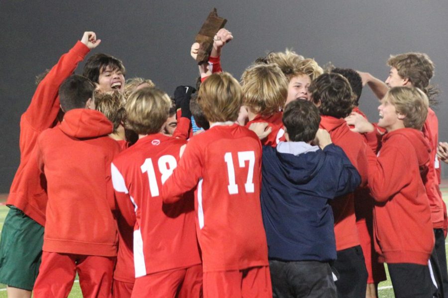 The team rallies and proudly waves their first district plaque. 