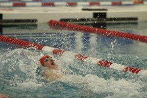 Wyatt Harris, sophomore, swims backstroke during a varsity swimming race. 