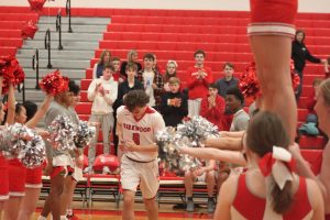 Landon Evans, senior, runs to the applause of cheerleaders and his team before the game.