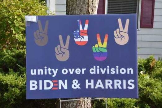 A Biden sign in a yard emphasizes the importance of unity.