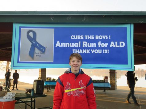 Nicholas Purschke stands in front of the Annual Run for ALD sign. Photo courtesy of the Purschke family. 