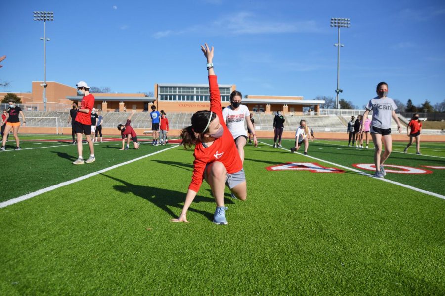 Athletes participate in warmup drills on the turf during in-person preseason workouts.