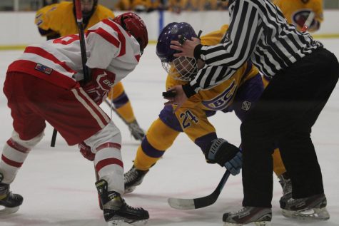 A player from each team prepares for the face-off for the puck.