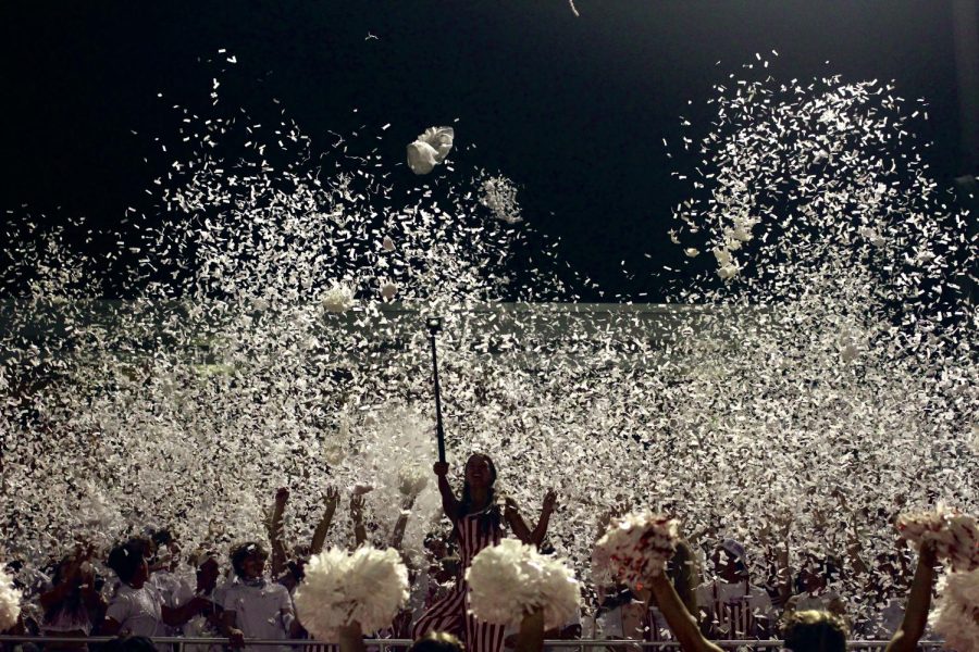 The students section throws white confetti in the air to celebrate the whiteout theme.