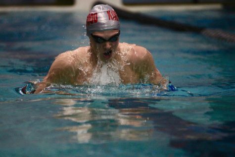 Adam Bauer, junior, comes up for a breath during his 100 Yard Breaststroke, finishing in 11th place.