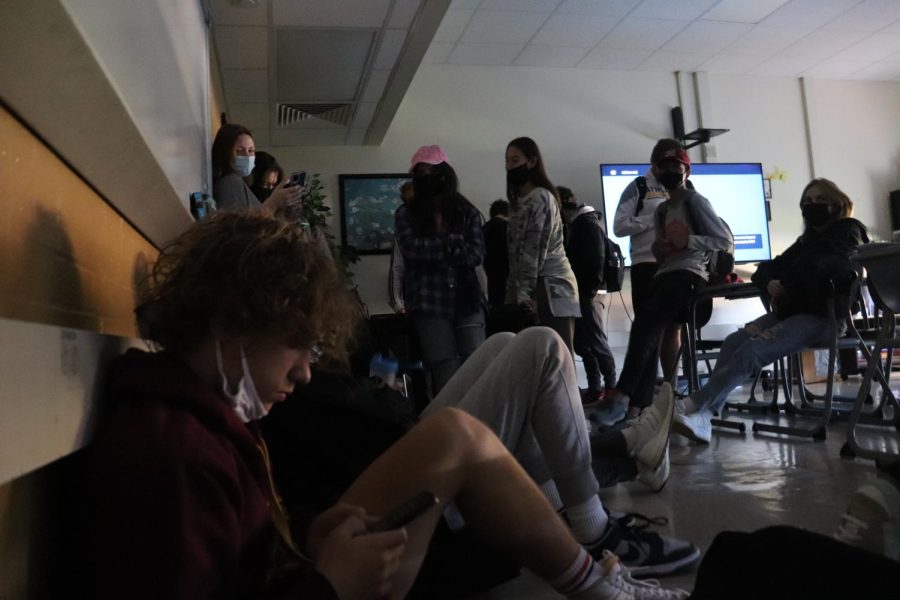 Students gather away from the classroom door after barricading it with desks. 