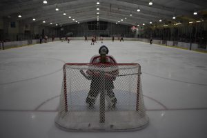 Goalie Morgan Miller, sophomore, watches the play across the rink from the goalie box.