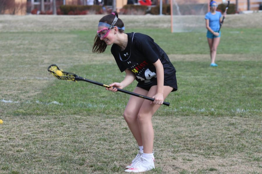 Malley McKean, sophomore, smiles as she picks up a ground ball.