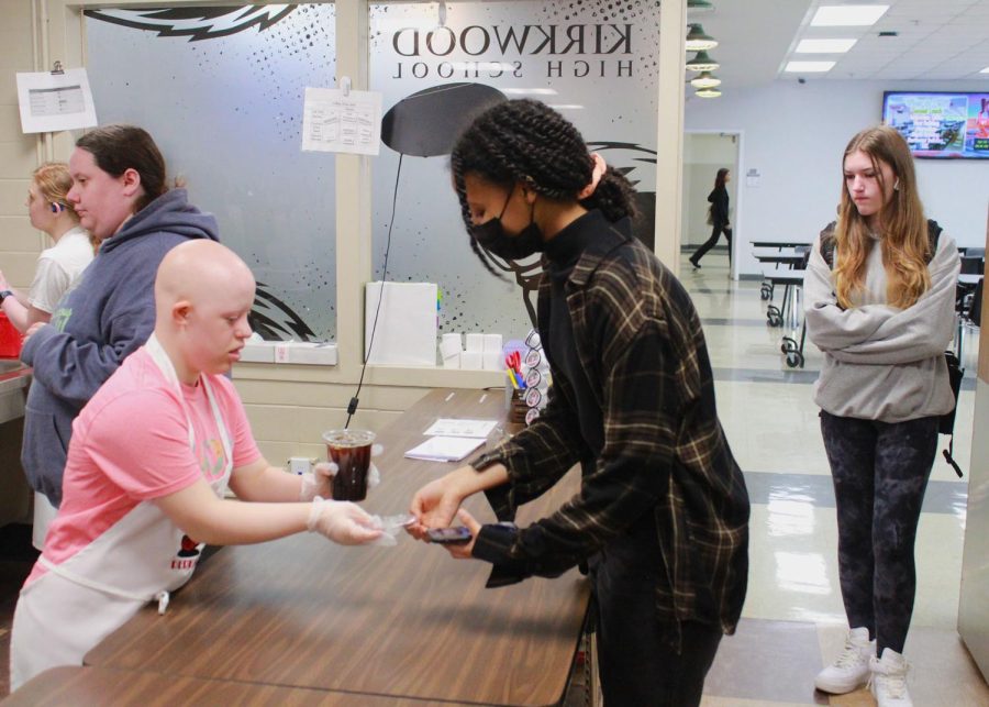 Barista Audrey Bernaboo (left) hands finished coffee to waiting customer.