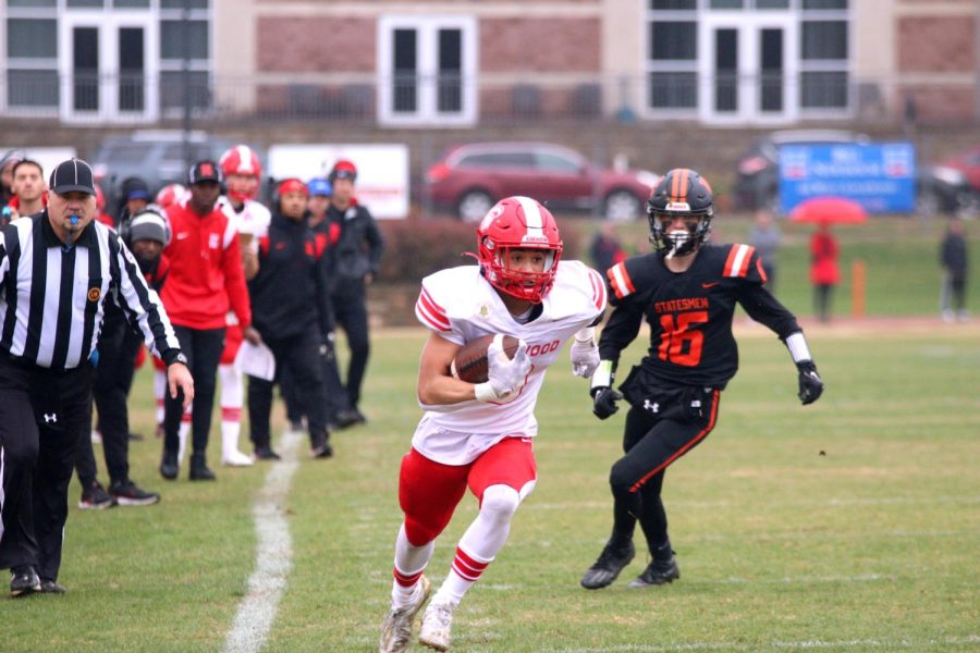 Tyler Macon, senior, runs down the field with the football tight in his arm.