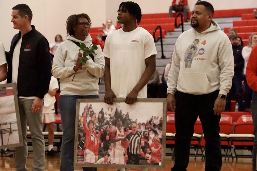 Aydan Trawick, senior, stands alongside his mother and father at center court. 