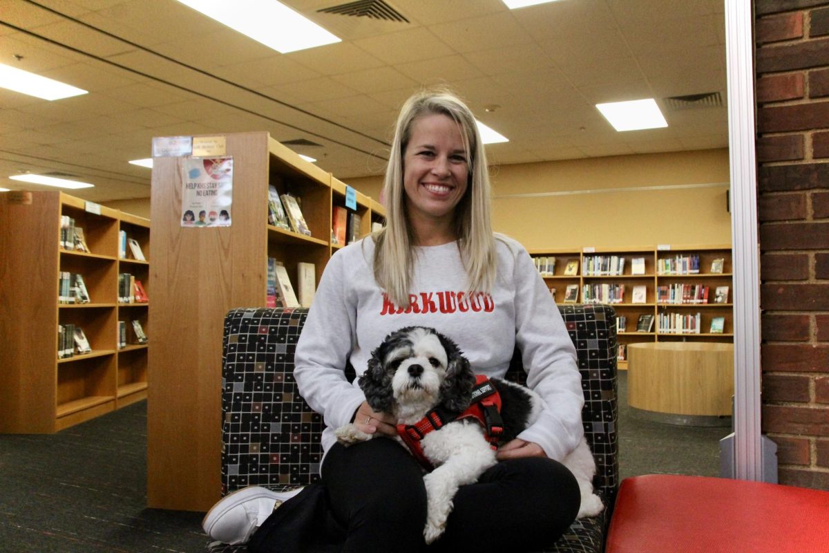 Nikki Luckett sits at a table in the Donald Duchek Library with her dog, Packer. 