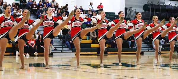 Kirkwood JV pommies do a high kick at the same time, while all linked together. 