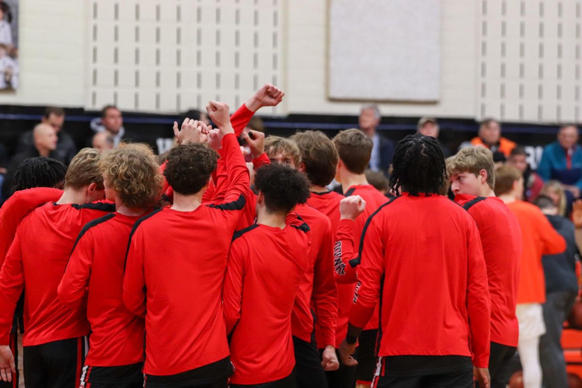 KHS varsity basketball huddle together after warmups to prepare for their game.