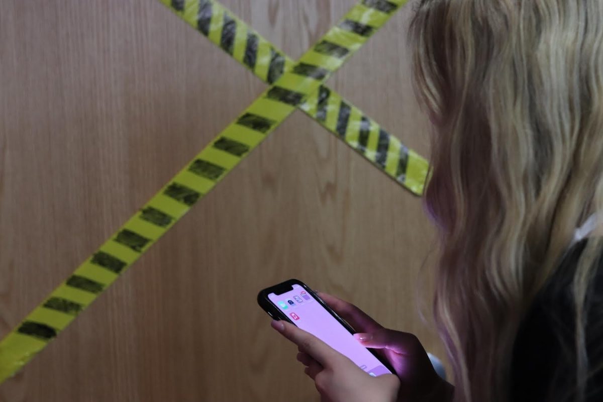 A teenager walks past the police tape, unbothered.